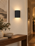 Black fluted wall sconce in a modern hallway