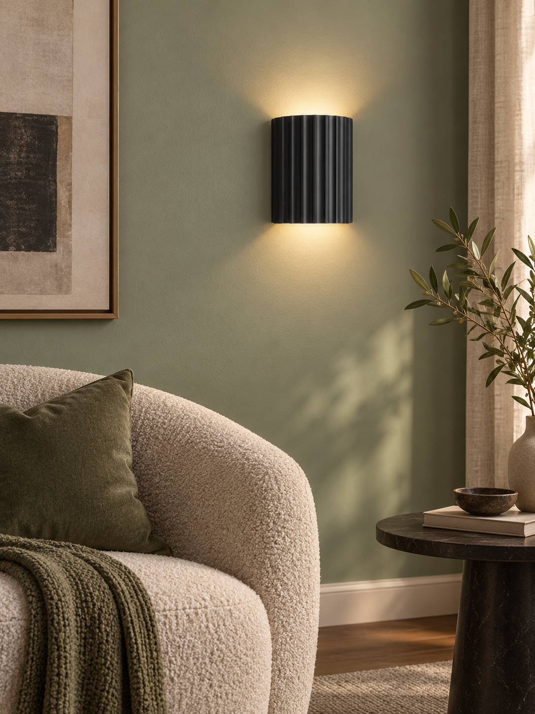 Black fluted wall sconce in a sage green reading corner