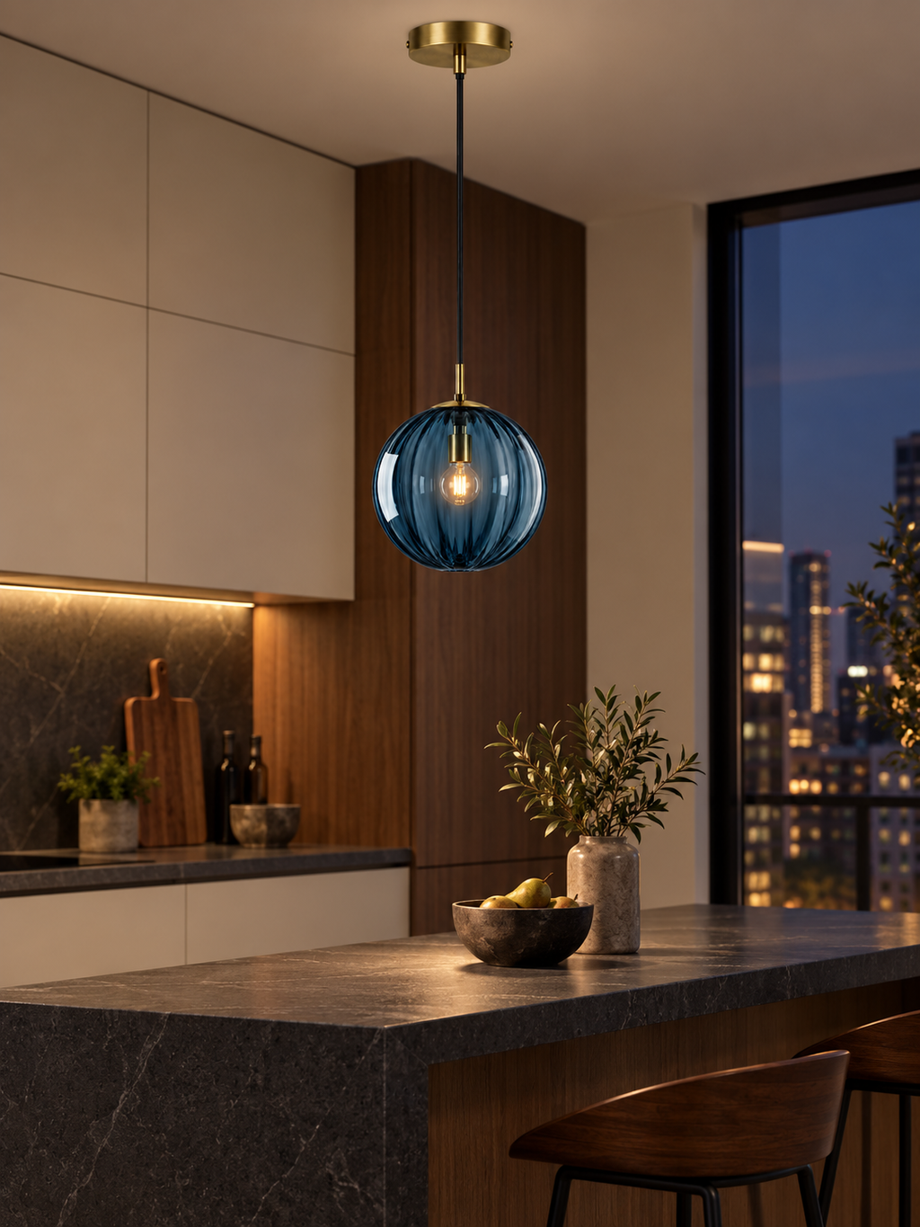 Blue glass globe pendant light above a modern kitchen peninsula