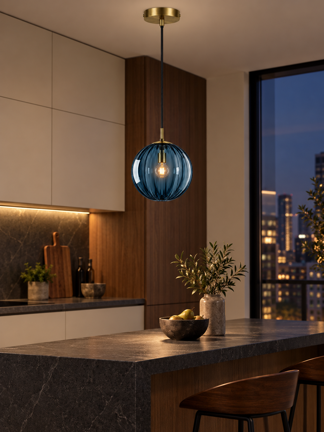 Blue glass globe pendant light above a modern kitchen peninsula