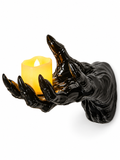 Black creepy hand wall candle holder with LED candle on a white background