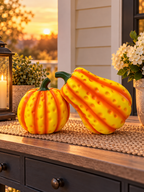Dimpled yellow-orange pumpkin sculpture set on a porch at sunset