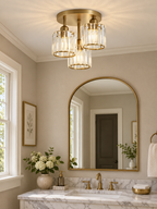 Gold three-light crystal ceiling fixture in a refined bathroom
