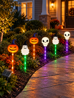 Six Halloween solar pumpkin ghost and skull pathway lights along a front walkway