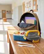 Insulated bento lunch box beside a backpack, daytime