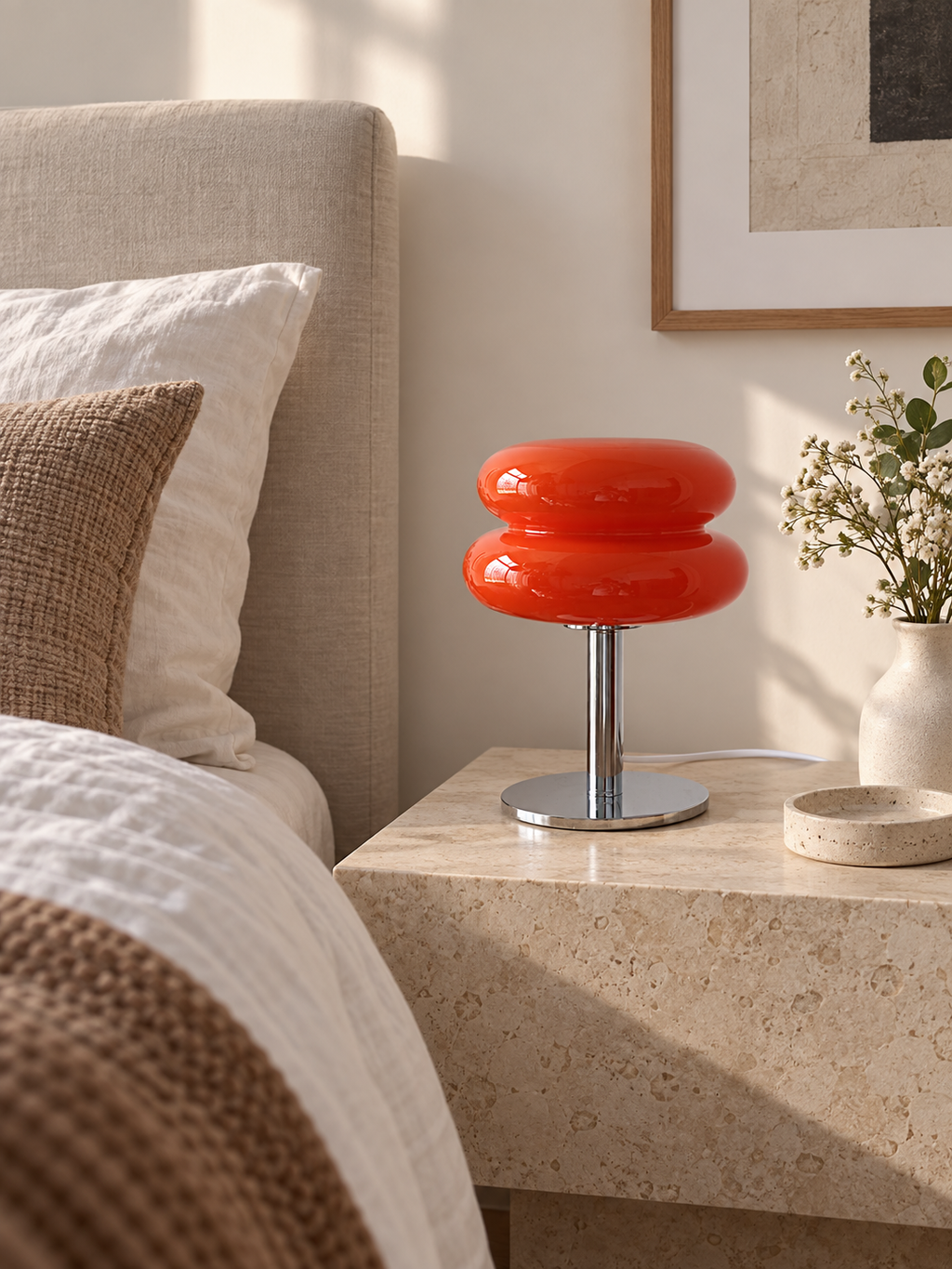 Orange red glass table lamp on a stone bedside table
