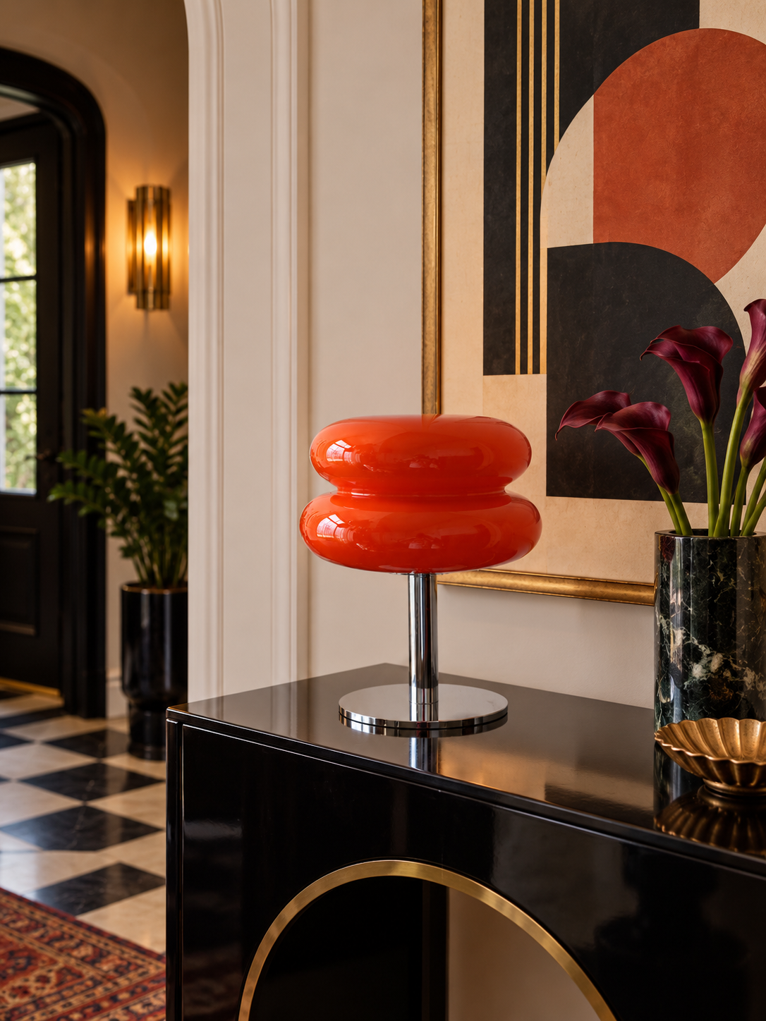 Orange red glass table lamp on a black art deco entryway console