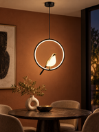 Magpie LED bird pendant light above a modern dining table