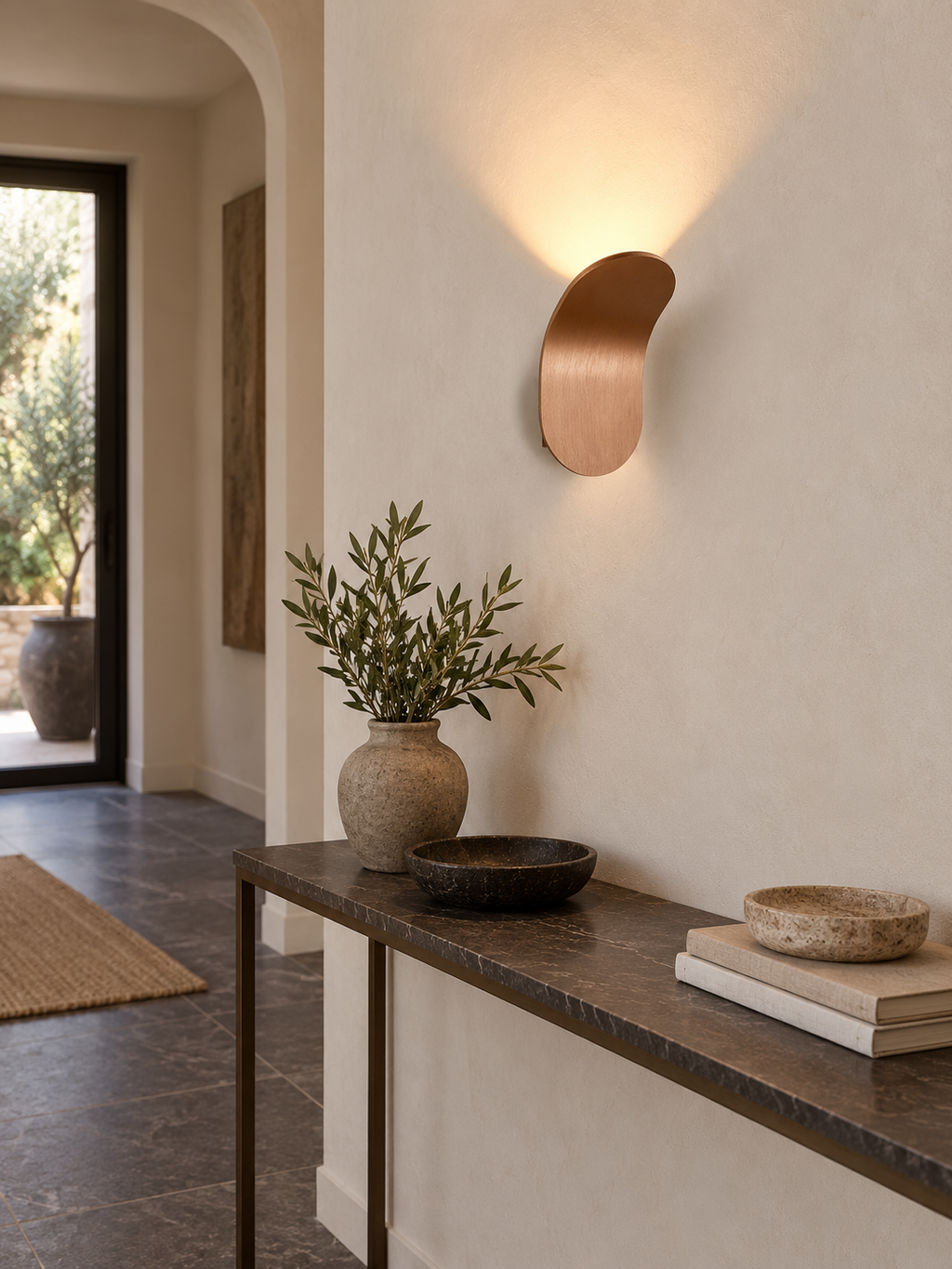 Brushed copper LED wall sconce above an entryway console