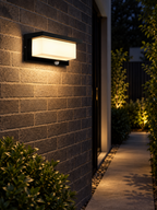 Outdoor motion sensor wall light illuminating a side walkway