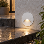 Weather-resistant recessed outdoor step light installed beside wet stone steps