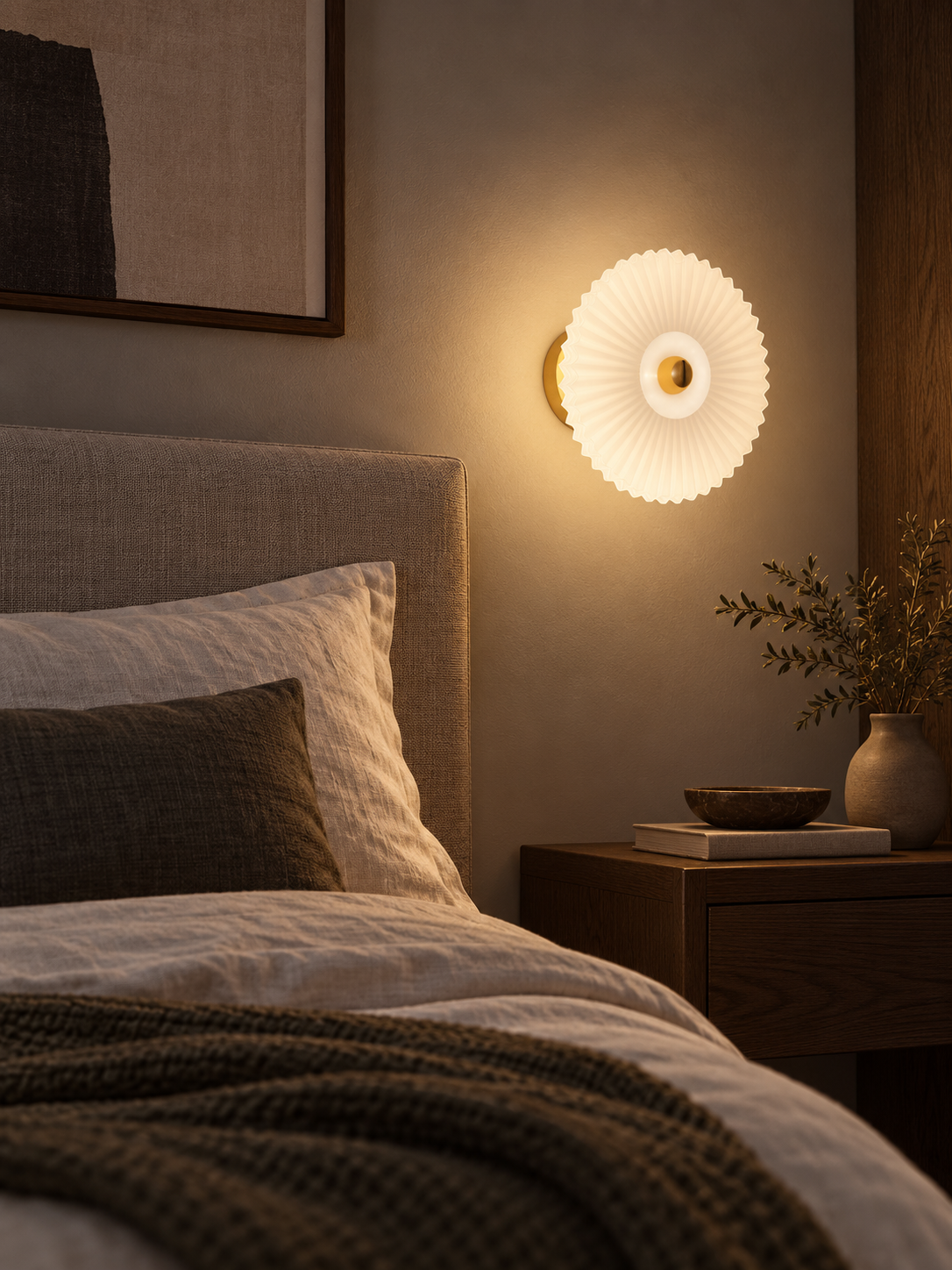 Pleated glass wall sconce beside a contemporary bed