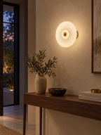 Pleated glass wall sconce above an entryway console