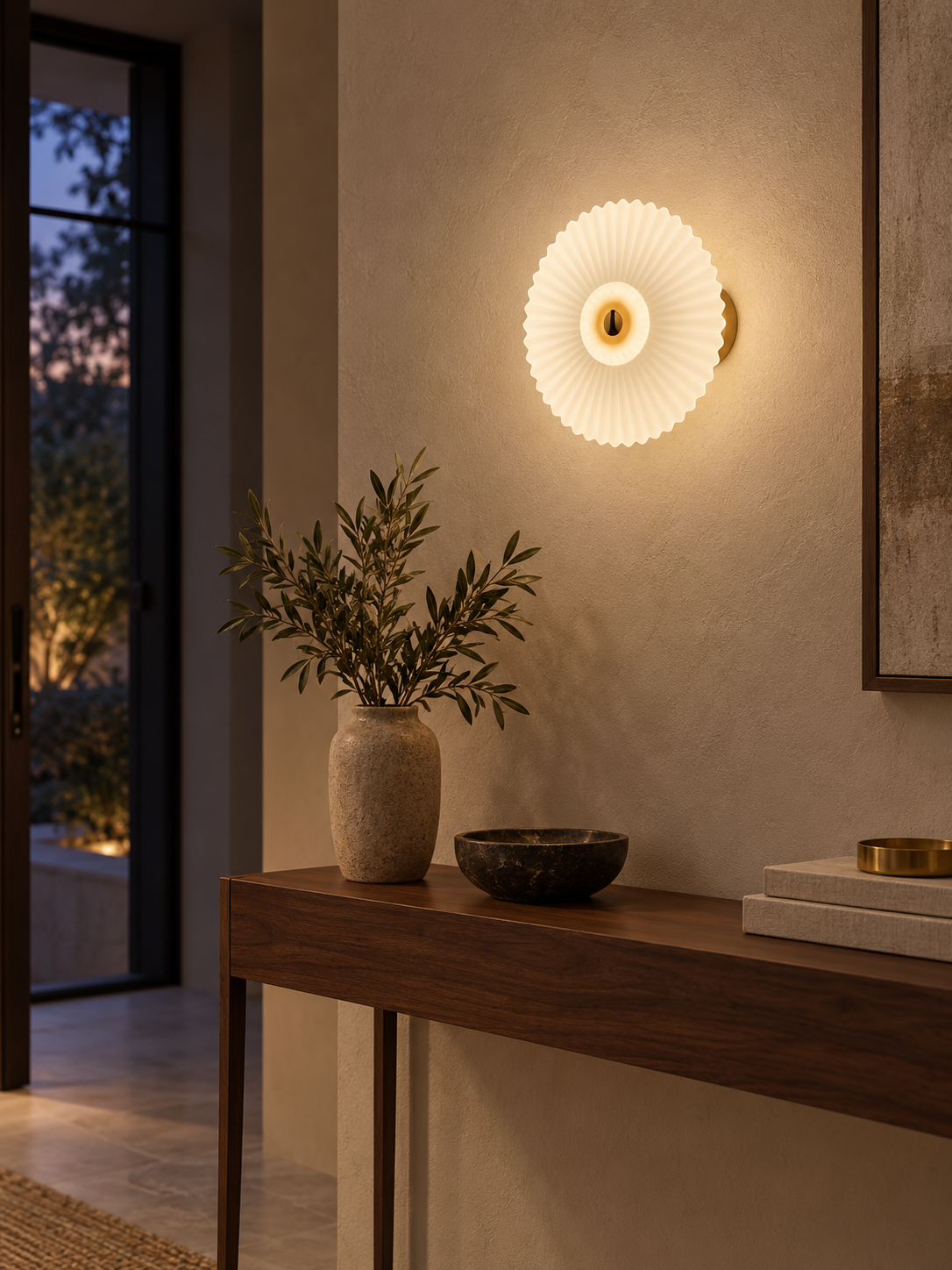 Pleated glass wall sconce above an entryway console