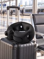 Black portable cervical travel pillow on luggage at a train station
