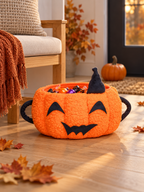 Orange pumpkin Halloween storage basket filled with candy beside a modern entryway bench
