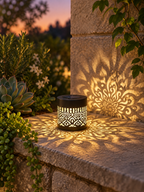 Solar decorative lantern glowing on a garden ledge