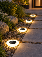 Four solar ground lights along a stone walkway
