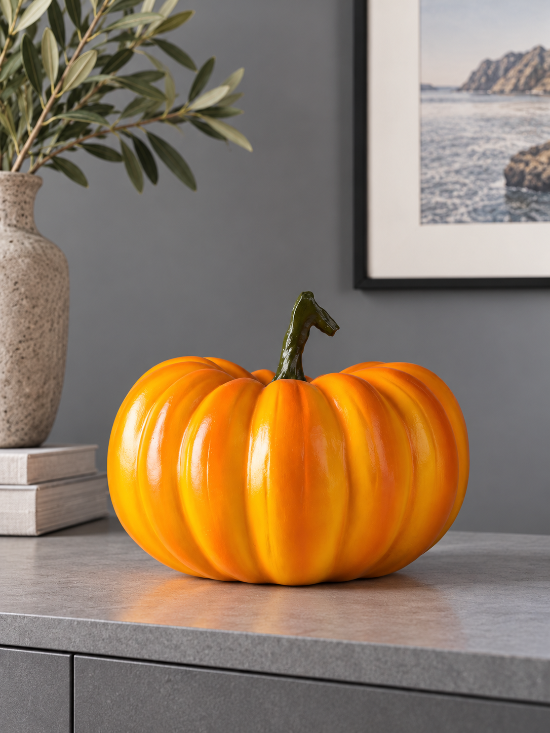 Squat glossy orange pumpkin figure on a minimalist gray console