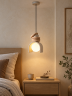 Wabi-sabi resin pendant light beside a minimalist bed
