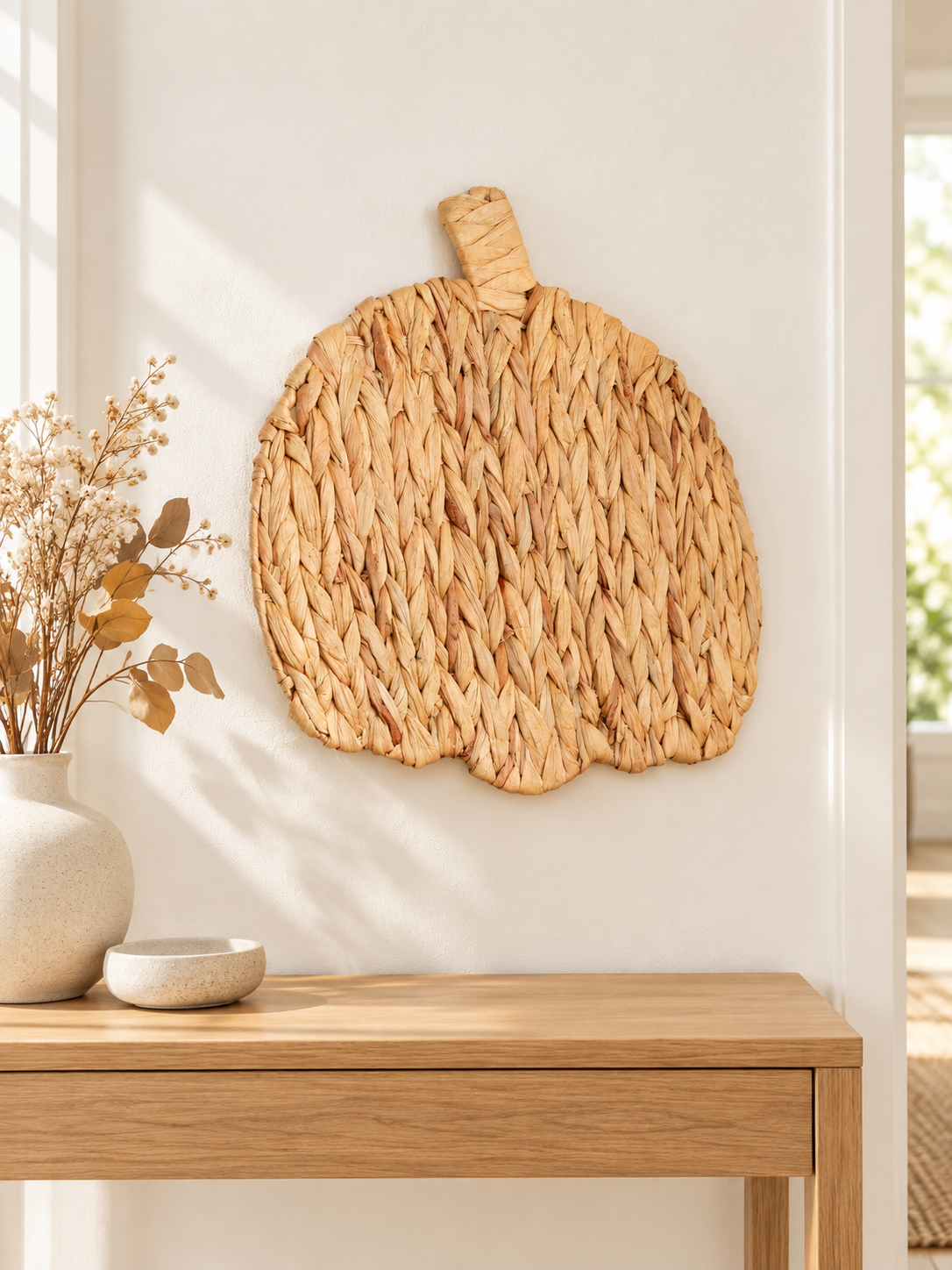 Natural woven pumpkin wall art displayed in a minimalist entryway